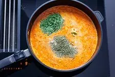 Hackfleischmasse wird mit Brühe, Sahne und Gewürzen zu einer cremigen Soße verarbeitet