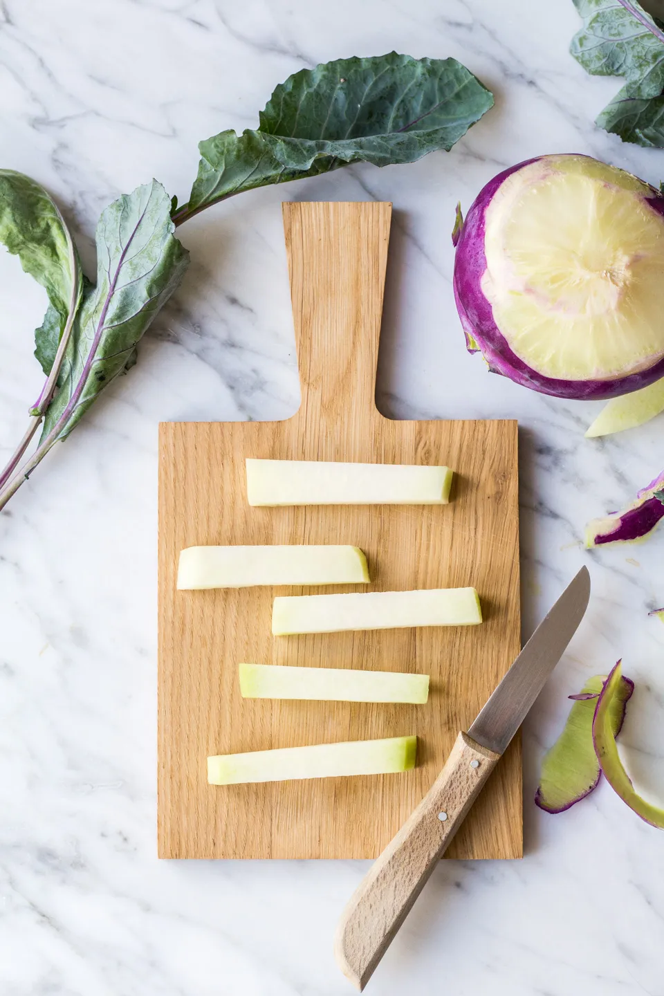 Hand hält gebackene Kohlrabi-Sticks mit Gewürzen