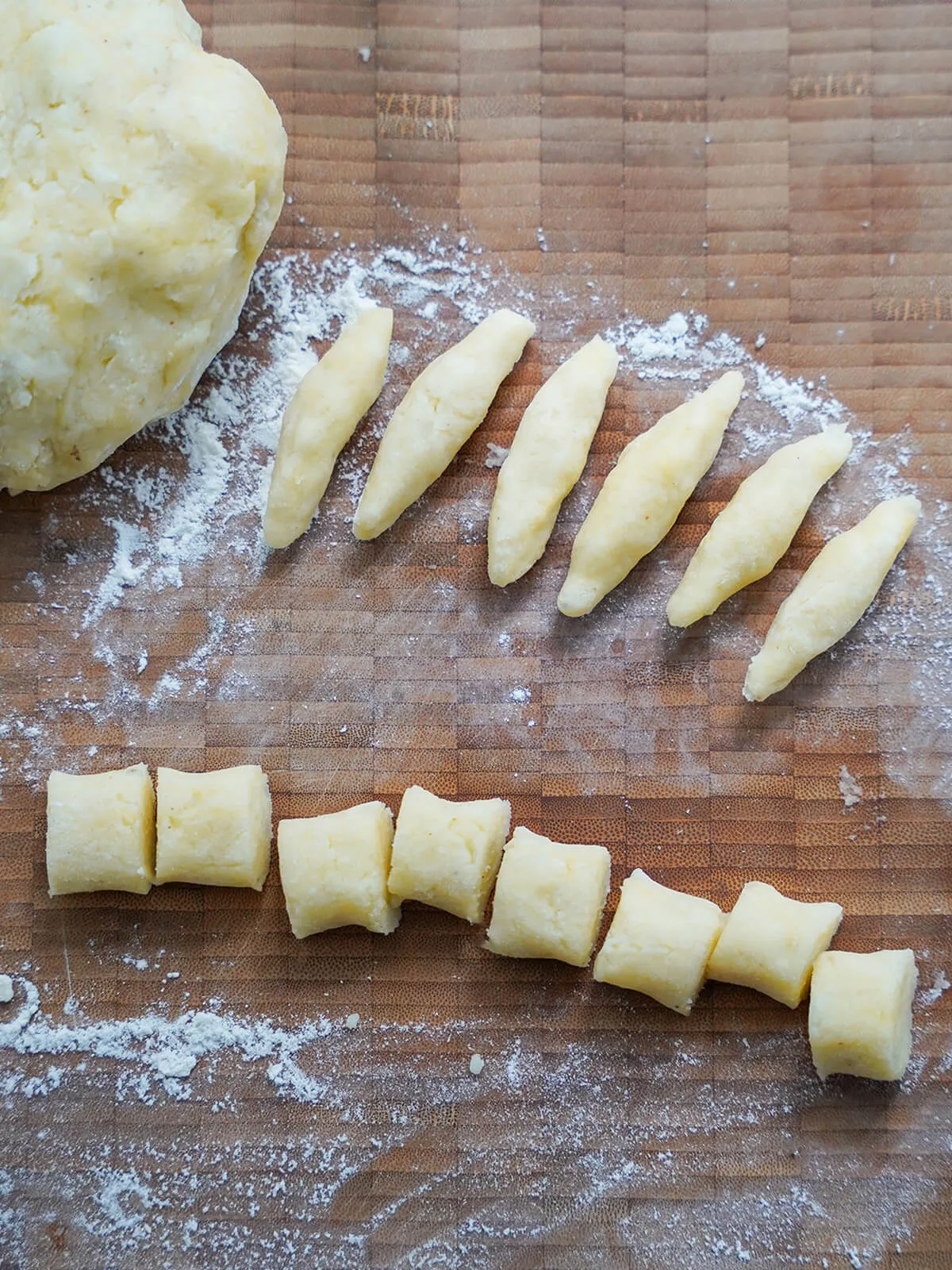 Handgemachte Schupfnudeln in verschiedenen Formen auf einer bemehlten Fläche