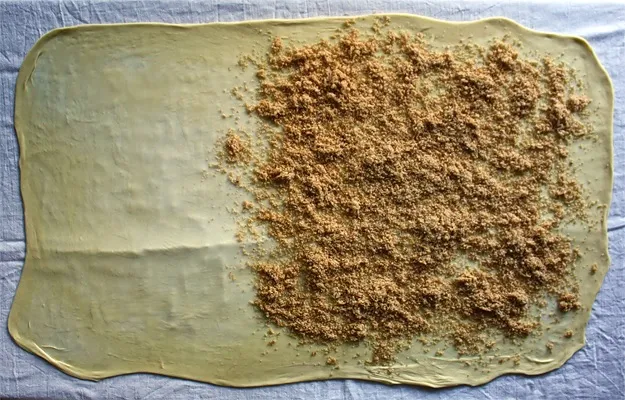 Hauchdünner Strudelteig mit zerlassener Butter und Semmelbröseln bestrichen, eine wichtige Schicht für das Strudel Rezept