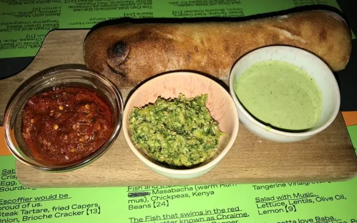 Hausgemachte Tel Aviv Focaccia mit drei verschiedenen Dips, darunter Hummus, serviert im Bar Shuka Frankfurt