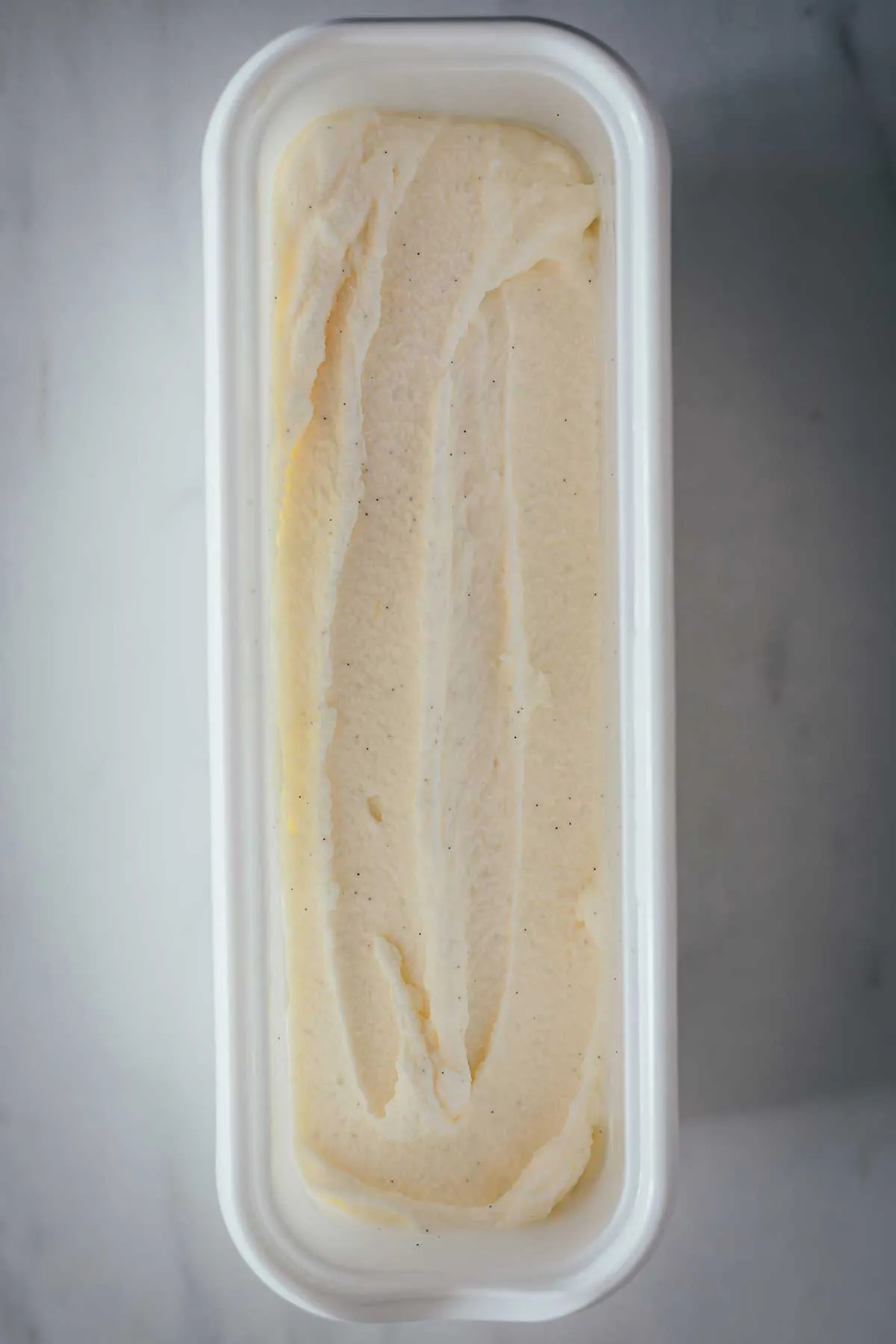 Hausgemachtes cremiges Vanilleeis ohne Ei in einer Schale, bestreut mit Vanillemark, perfekt für den Sommergenuss.