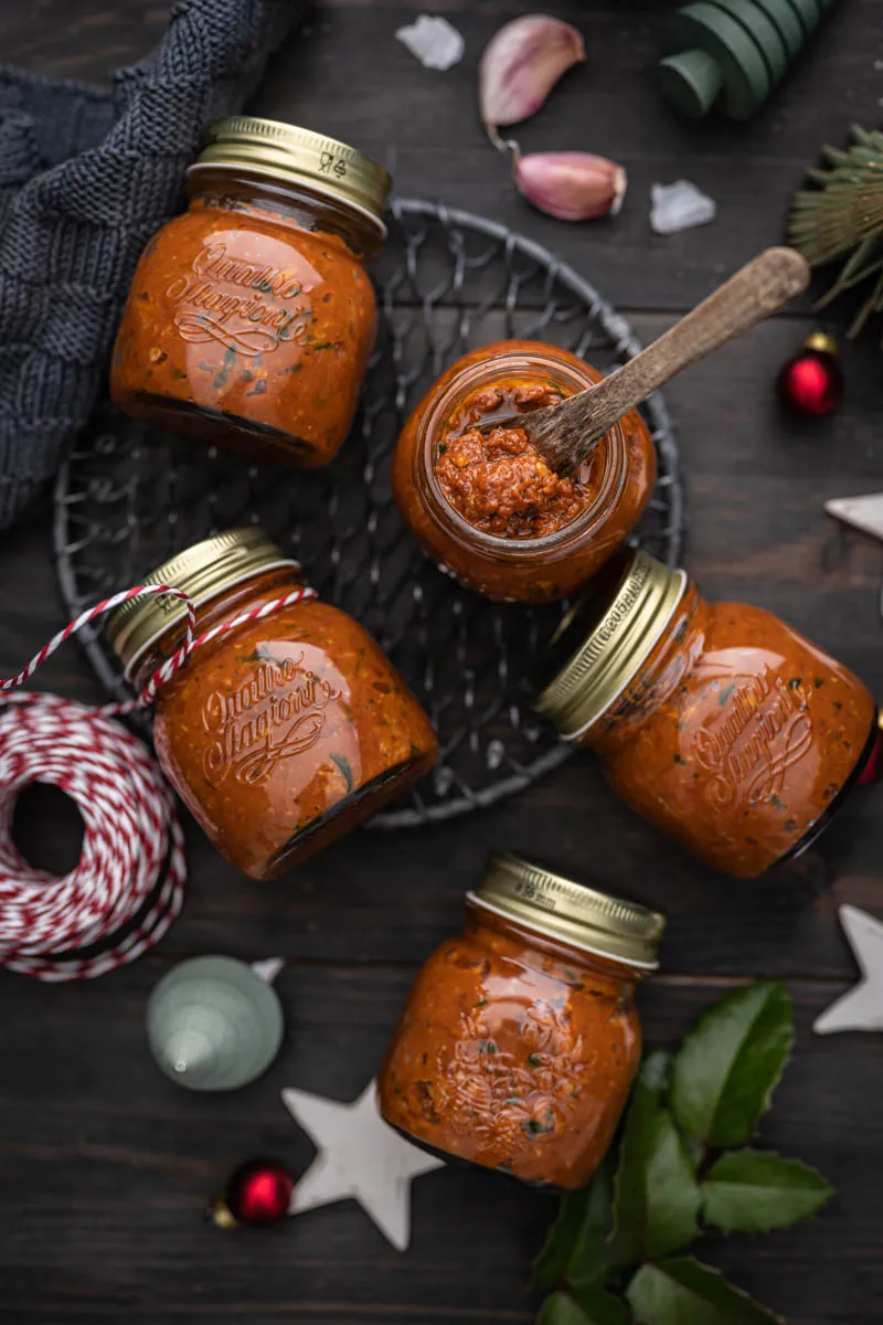 Hausgemachtes veganes Tomaten-Pesto in einem Glas mit frischen Kräutern
