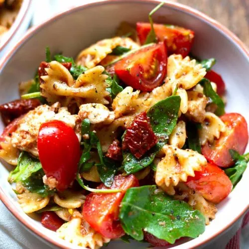 Headerbild für das Rezept: Mediterraner Nudelsalat mit Tomaten, Rucola und Mozzarella, perfekt präsentiert als schnelles und einfaches Gericht.