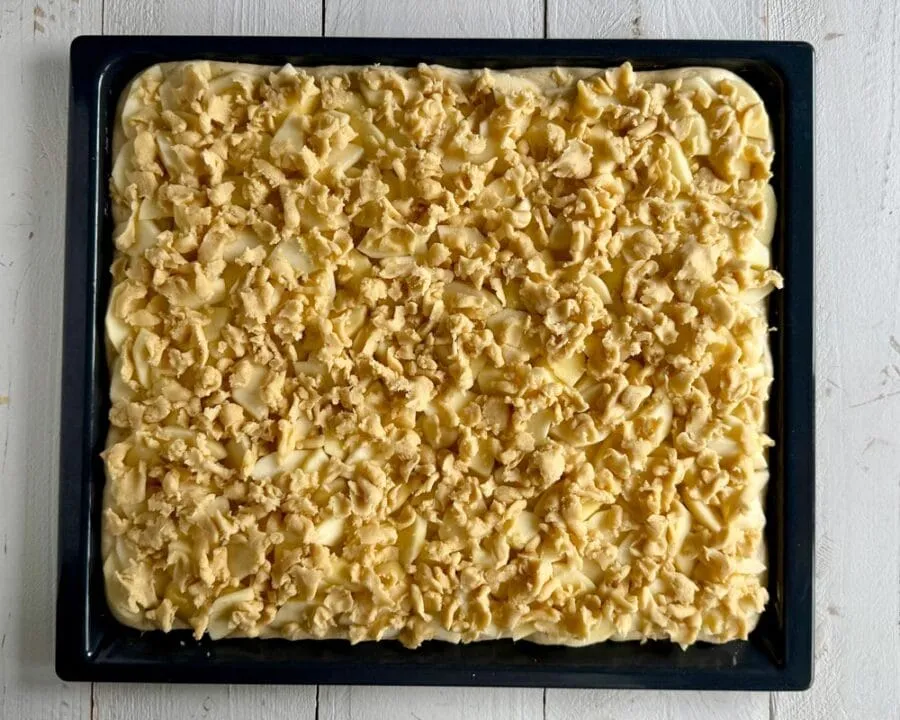 Hefe-Apfelkuchen mit Streusel vor dem Backen.