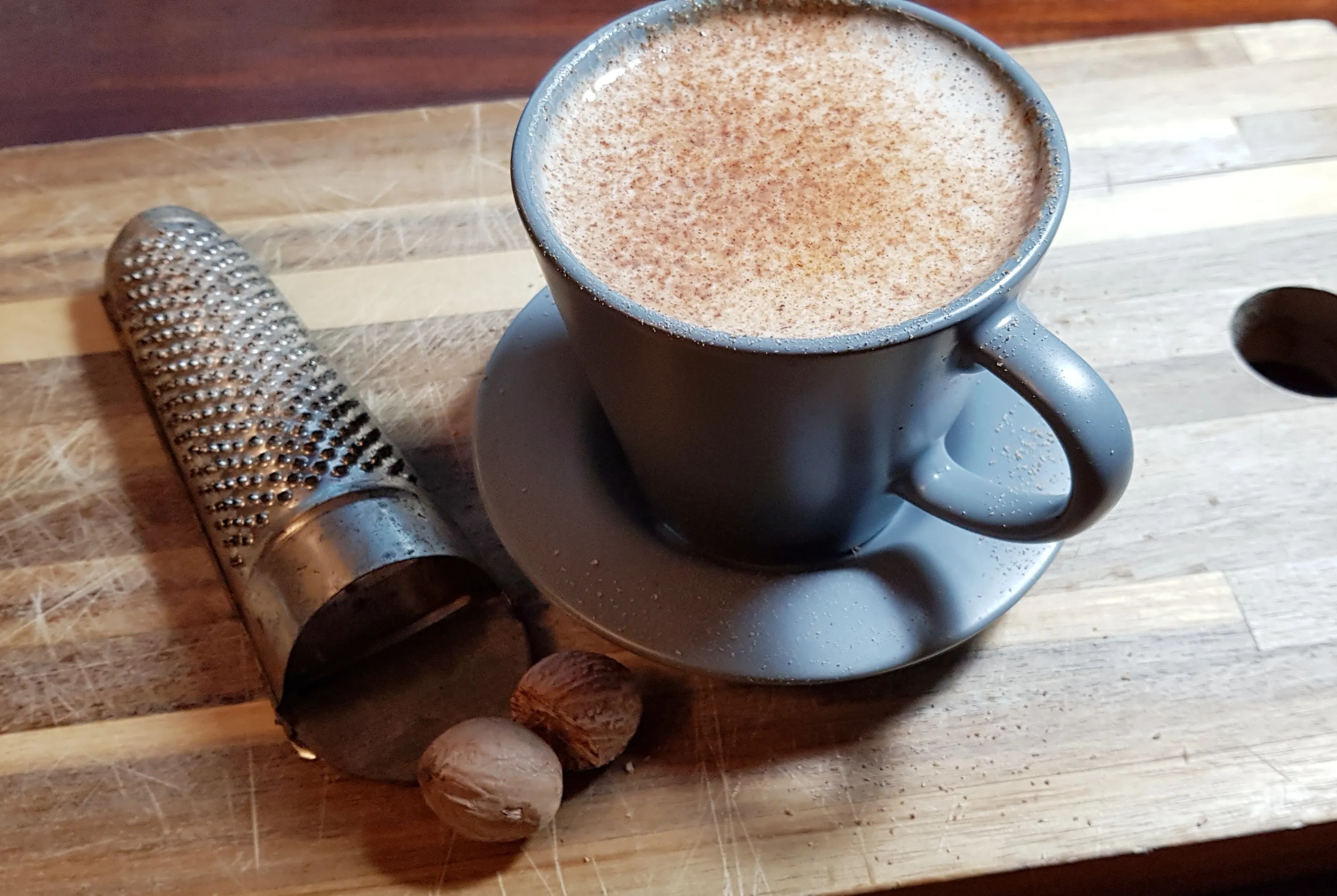 Heißer irischer Milch-Punch in einem Glasbecher auf einem Holztisch