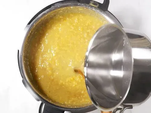 Heißes Wasser hinzufügen, um die Dal-Konsistenz anzupassen