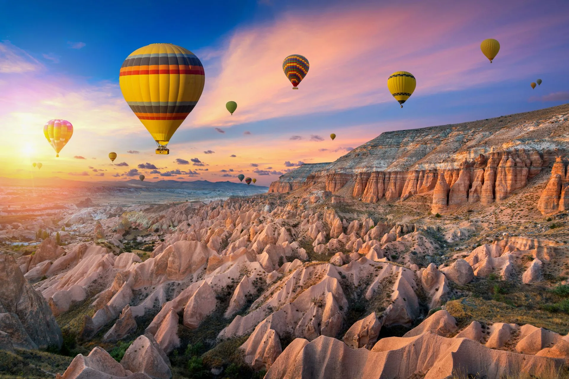 Heißluftballons schweben über den bizarren Felsformationen Kappadokiens im Göreme Nationalpark, Türkei