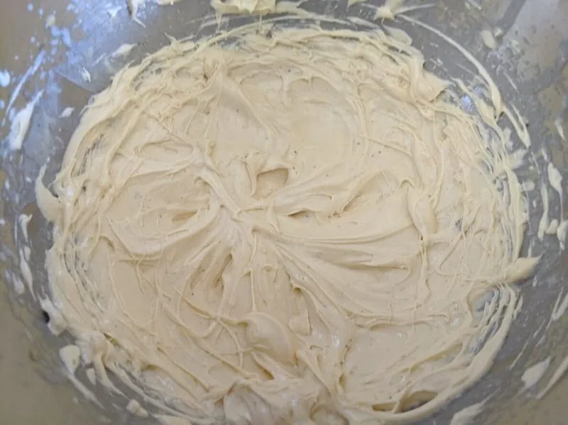 Helle Paradiescreme in einer Schale mit einem Schneebesen, bereit zum Servieren