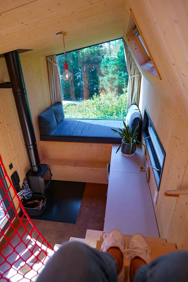 Heller Wohnbereich im Green Tiny House mit Sitzgelegenheit vor großem Fenster