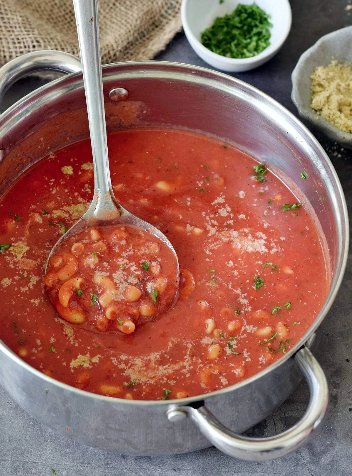 Herrlich wärmende vegane Tomaten-Nudelsuppe in einem großen Topf mit Schöpflöffel, schnell zubereitet als herzhaftes Mittagessen.