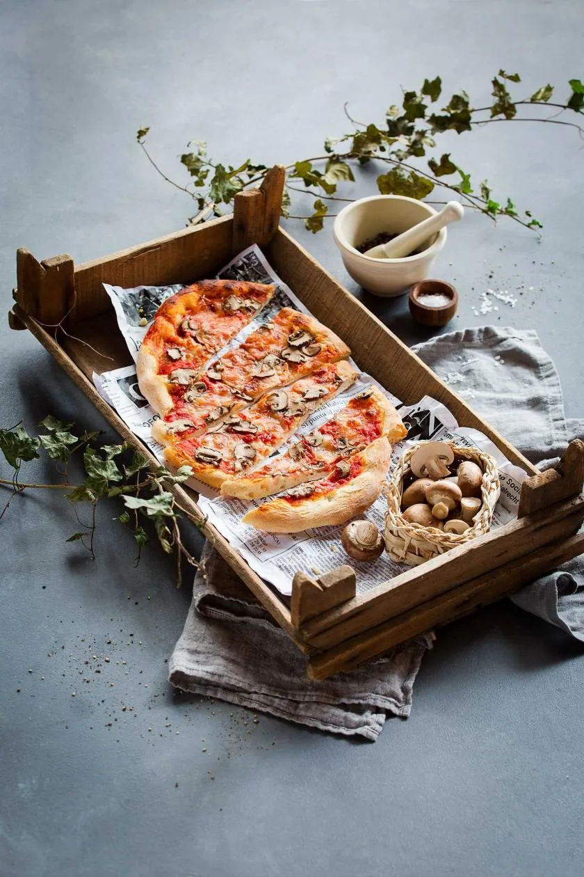 Herzhafte Pizza Funghi mit reichlich Champignons, Mozzarella und Kräutern auf knusprigem Boden.