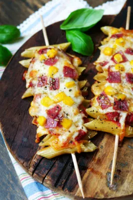 Herzhafte Pizza-Pasta-Sticks mit Mais, Salami und Käse, appetitlich überbacken