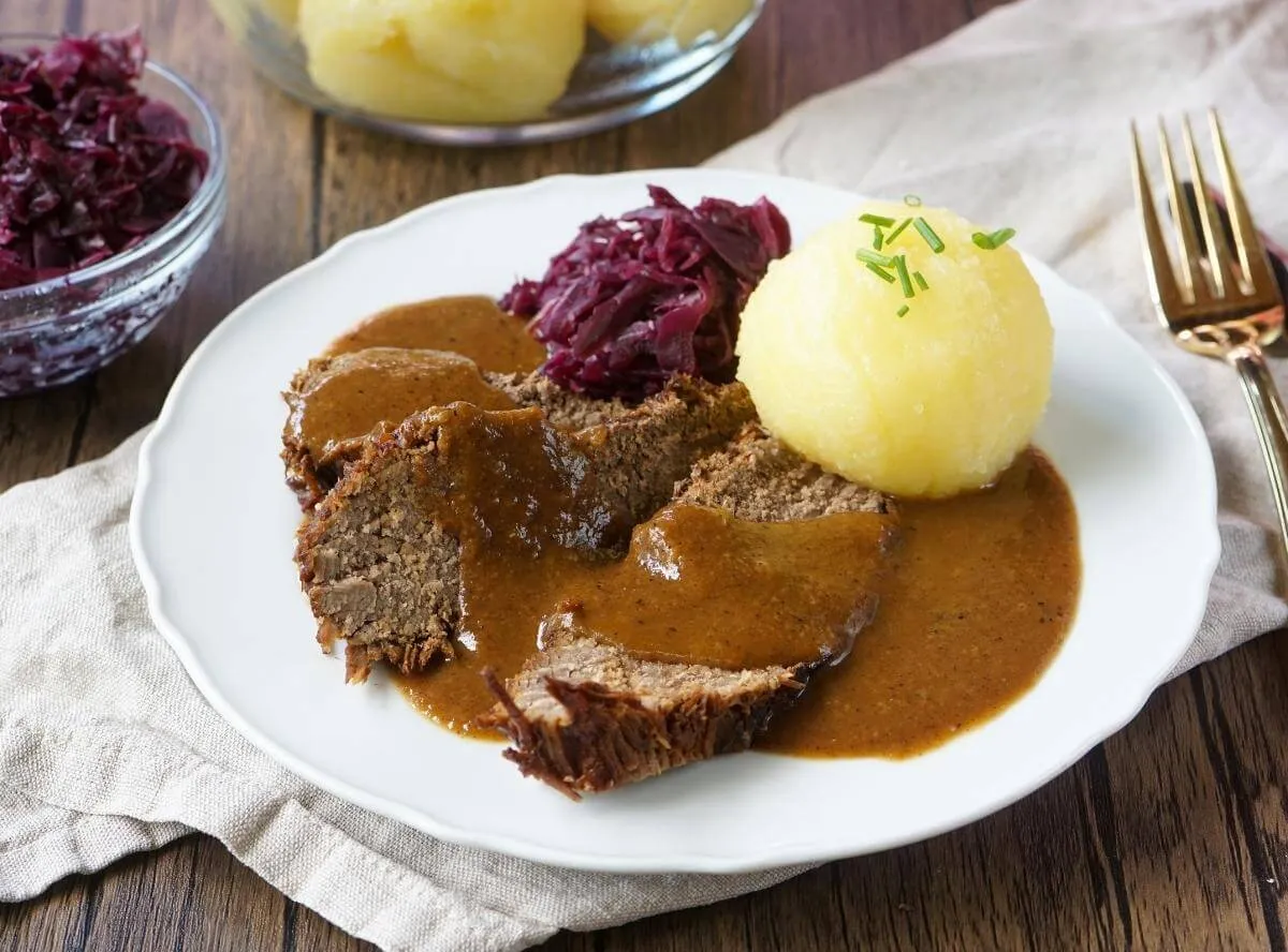 Herzhafter Sauerbraten mit dunkler Soße und Knödeln, ein deftiges Sonntagsessen aus Omas traditioneller Küche