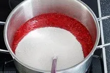 Himbeermus mit Gelierzucker und Zitronensaft in einem Topf, bereit zum Kochen für die Himbeermarmelade.