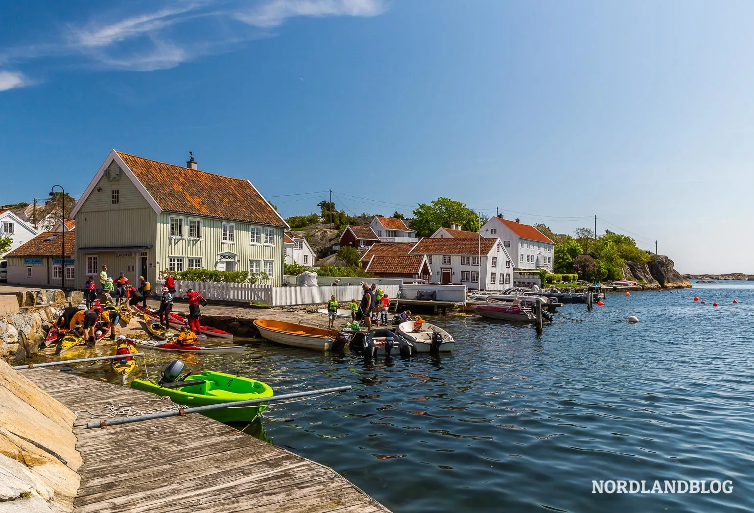 Historische Holzhäuser säumen die Küstenlinie des Fischerdorfes Brekkestø in Südnorwegen