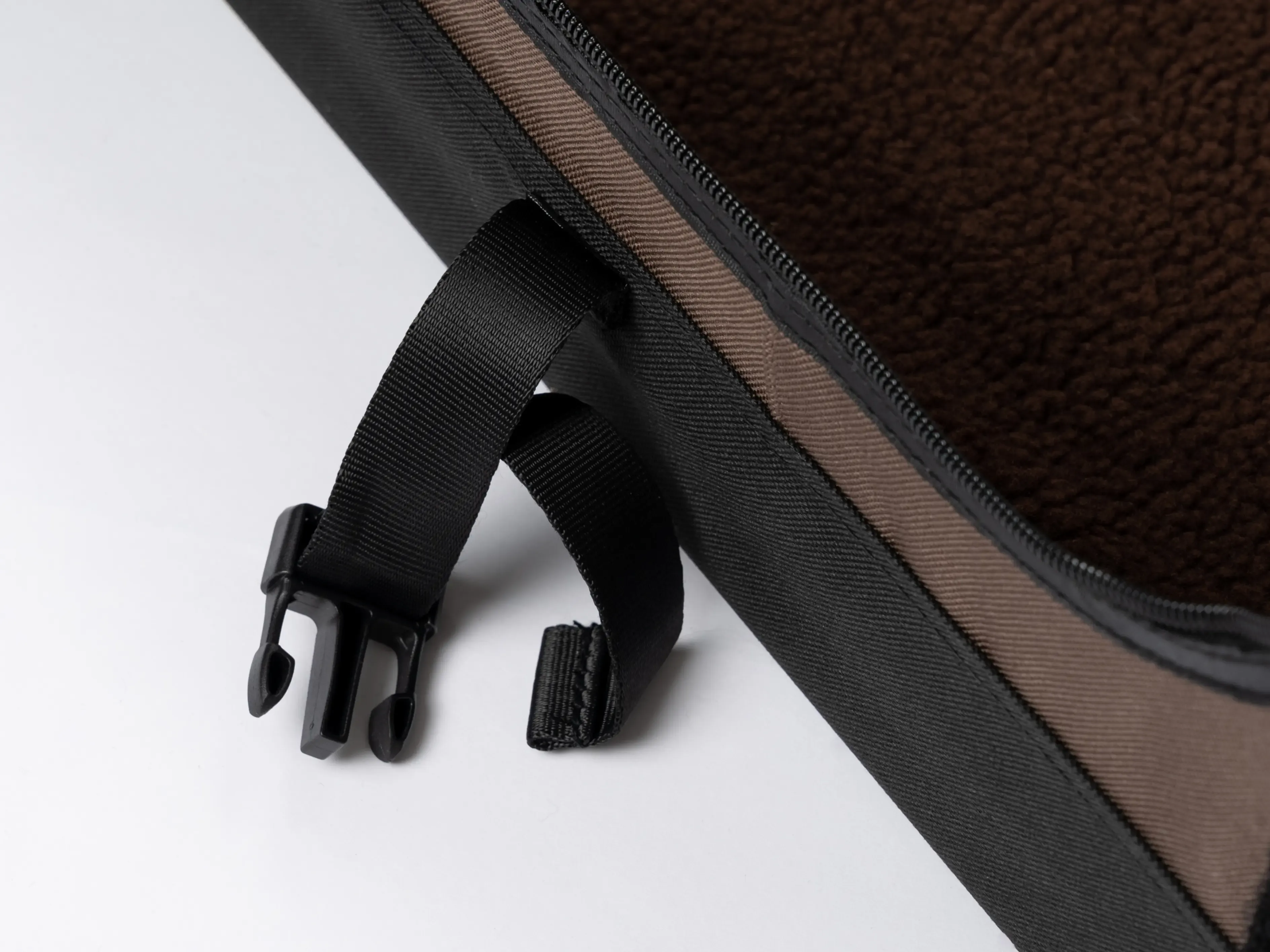 Hundebesitzer sichert eine faltbare Hundebox TPX-Pro im Kofferraum eines Autos mit einem Gurt