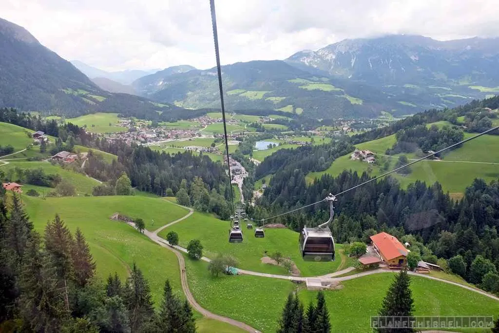 Idyllische Almwiese in den Kitzbüheler Alpen mit traditionellem Holzzaun und blühenden Blumen