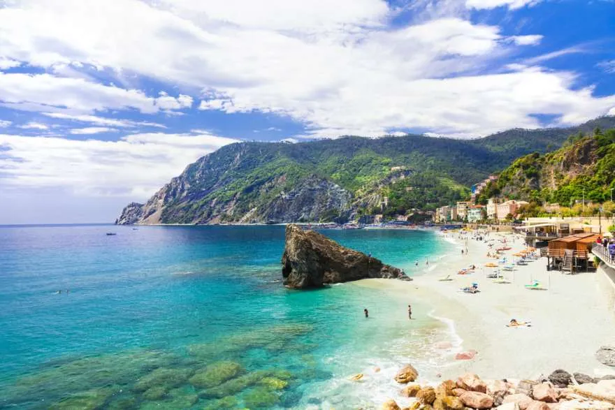 Idyllischer Strand in den Cinque Terre, Italien, umgeben von malerischen Klippen und bunten Häusern