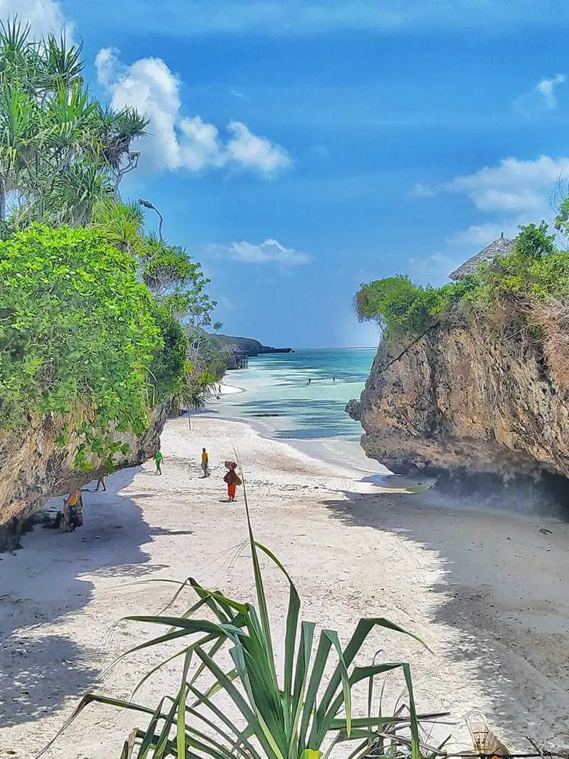 Idyllischer Strand in Sansibar, Tansania, mit türkisblauem Wasser und traditionellen Booten – ein tropisches Fernreiseziel im Sommer