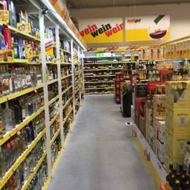 Innenansicht eines Trinkgut Getränkemarktes mit langen Gängen voller Bierregale und vielfältigen Trinkgut Bier Angeboten