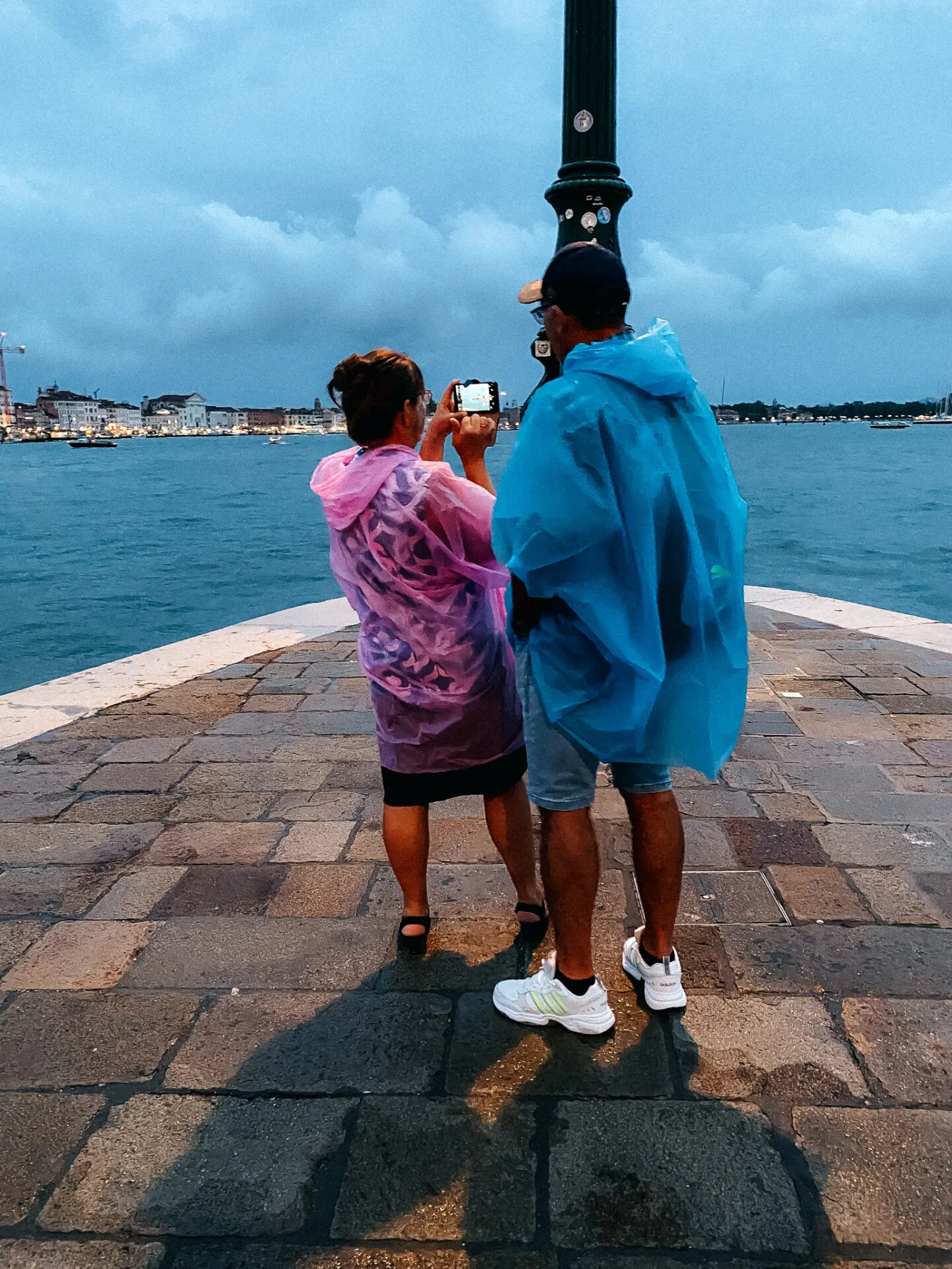 Junge Frau hält Handy in Venedig