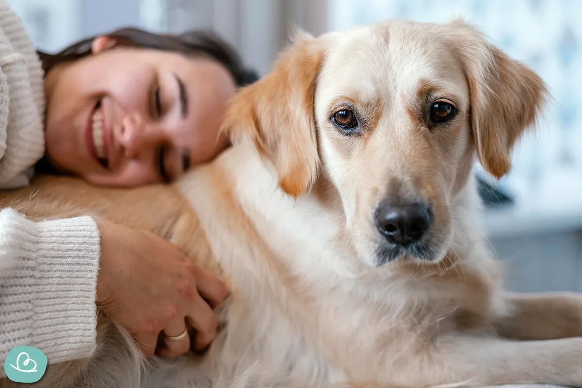 Junge Frau kuschelt liebevoll mit einem Golden Retriever Welpen