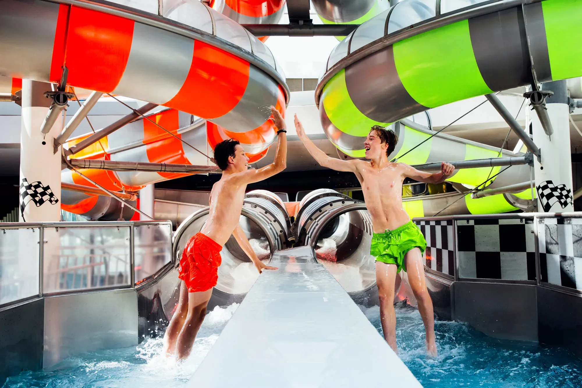 Jungen geben sich High Five vor der Speedrutsche in der Therme Erding