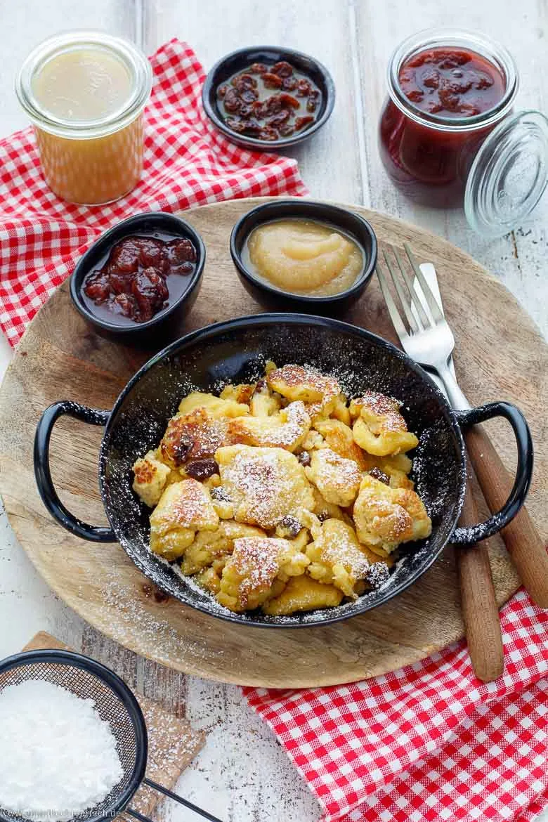 Kaiserschmarrn klassisch mit Rosinen und Puderzucker auf einer Holzhütte