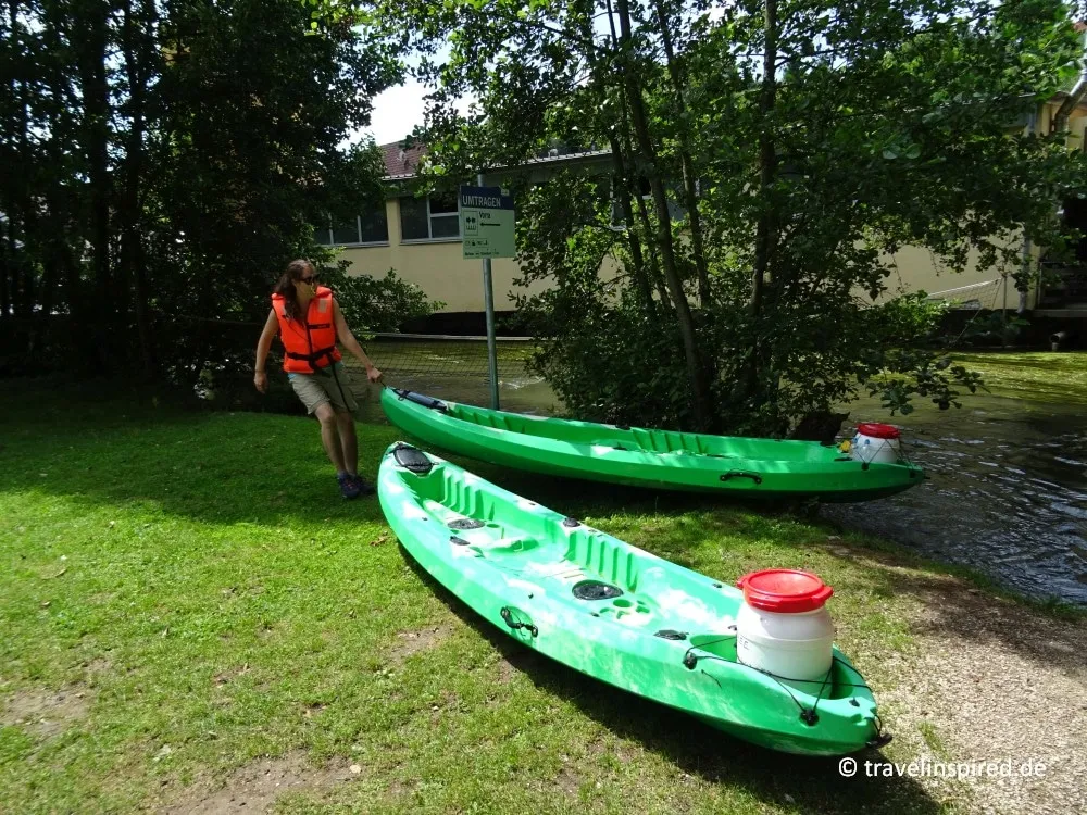 Kajaks werden an einer nicht befahrbaren Stelle an der Pegnitz umgetragen