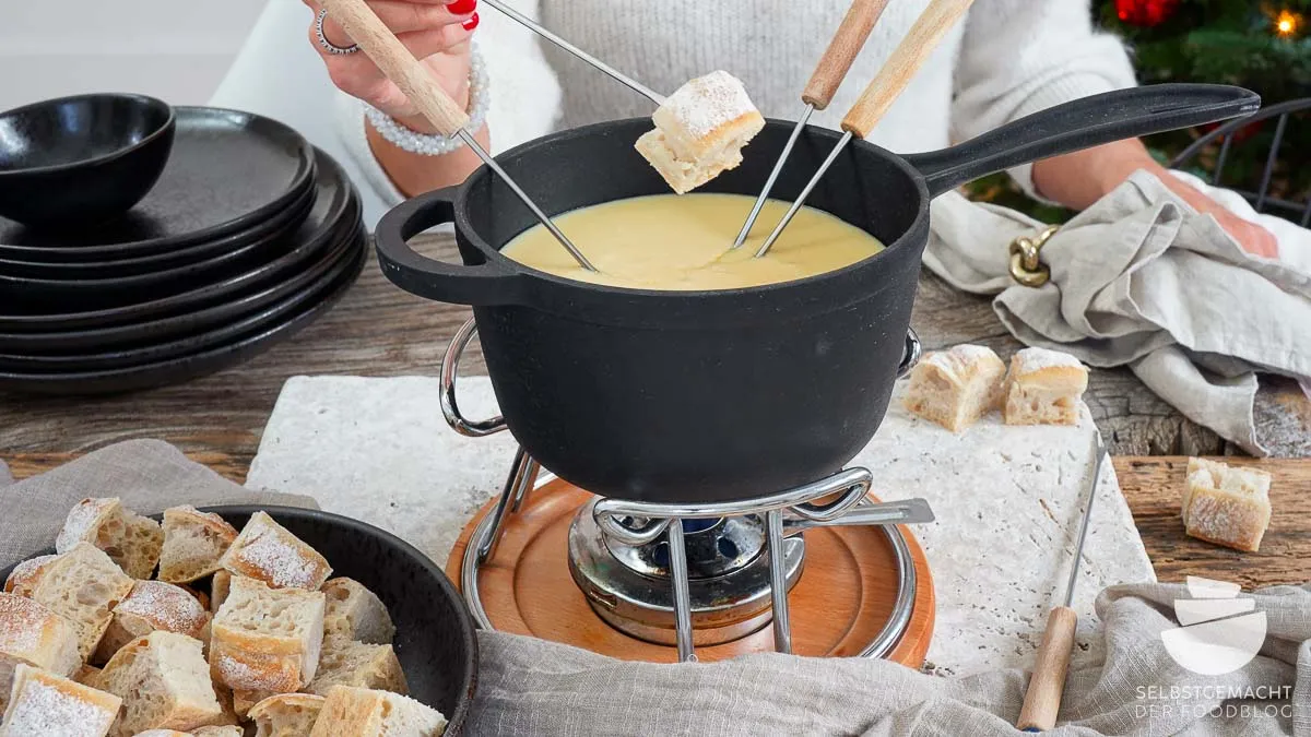 Käsefondue mit Brotwürfeln bereit zum Dippen
