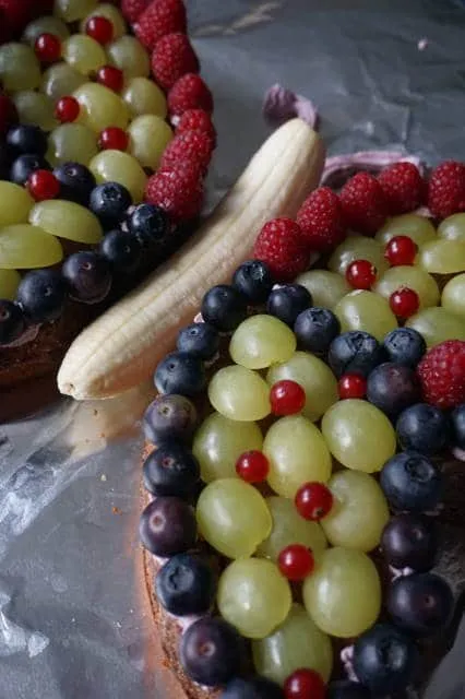 kindergeburtstagskuchen schmetterling mit frischen beeren dekoriert, ideal für den ersten geburtstag