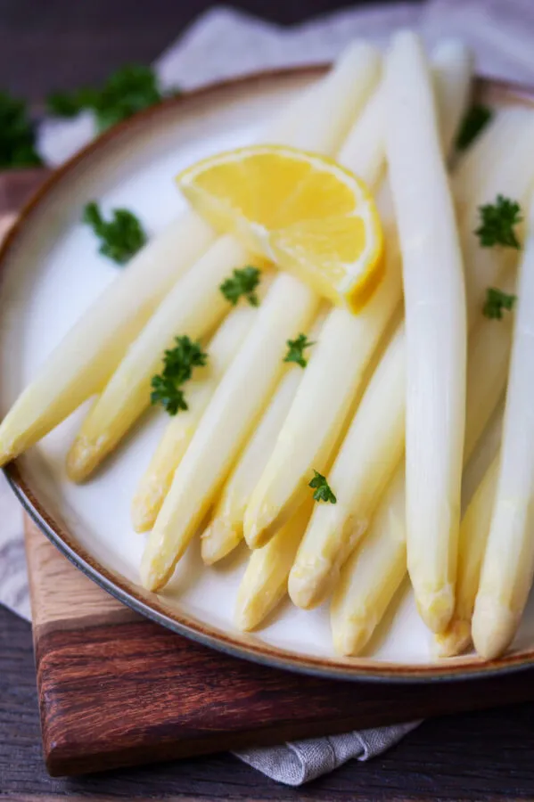Klassisch zubereiteter weißer Spargel mit Zitrone und Petersilie, ein einfaches Gericht, das die deutsche Spargelzeit zelebriert.