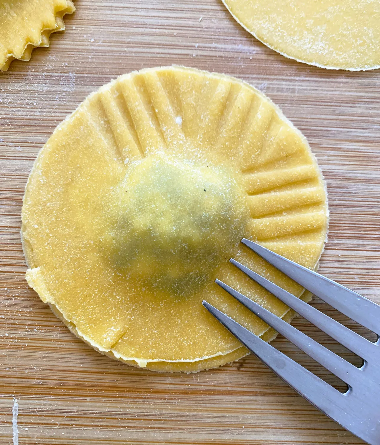 Klassische Spinat-Ricotta-Ravioli fertig geformt auf einer bemehlten Oberfläche
