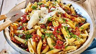 Klassischer italienischer Nudelsalat mit Tomaten, Oliven und Parmesan, ein mediterraner Picknick-Hit