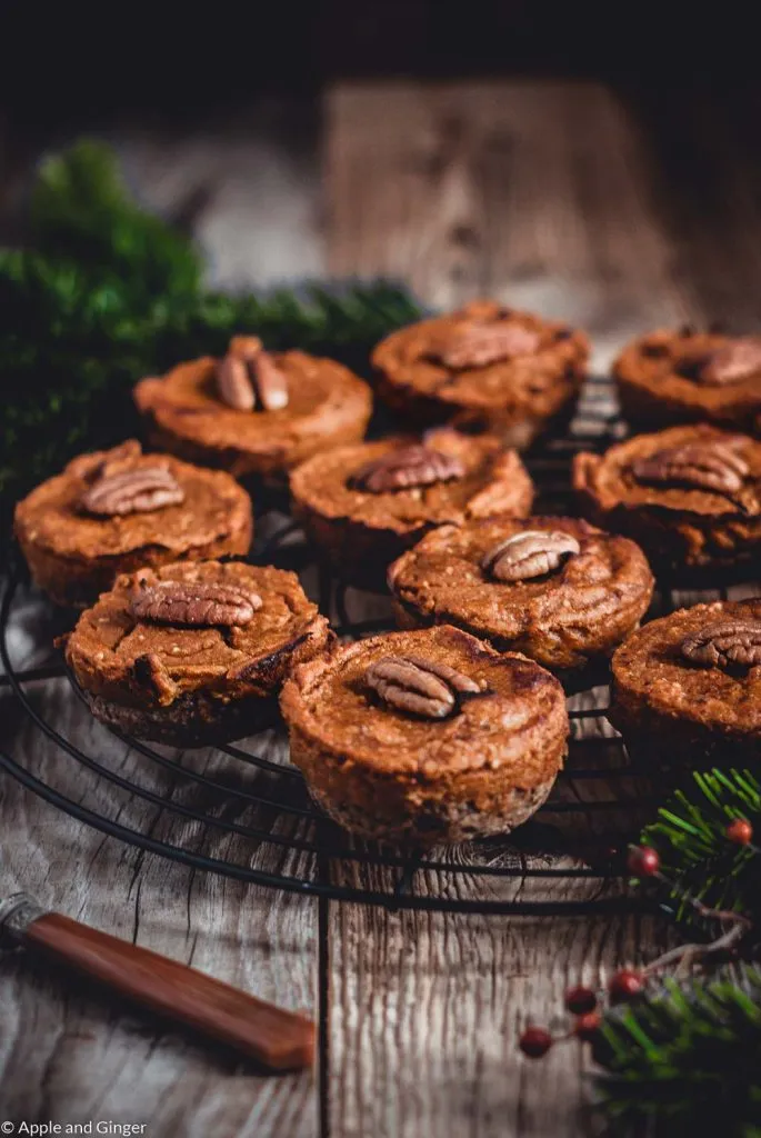 Kleine Bratäpfel, dekoriert mit Tannenzweigen auf einem Rost, als festliches Weihnachts-Dessert
