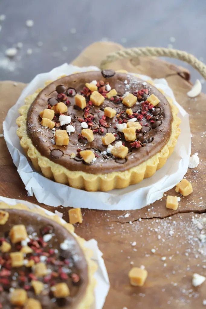 Kleine Nutella-Cheesecake-Tartelettes mit glänzender Schokoschicht, perfekt für süße Momente.