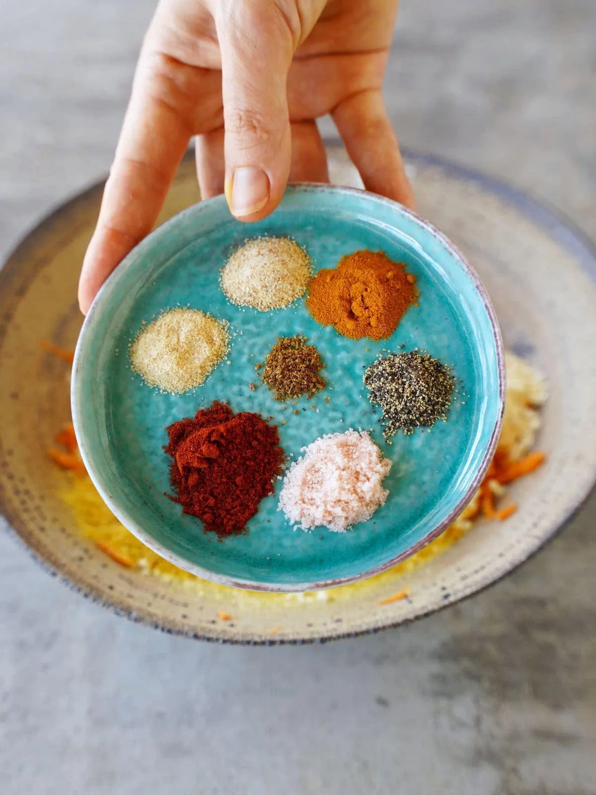 kleiner Teller mit Gewürzen in der Hand