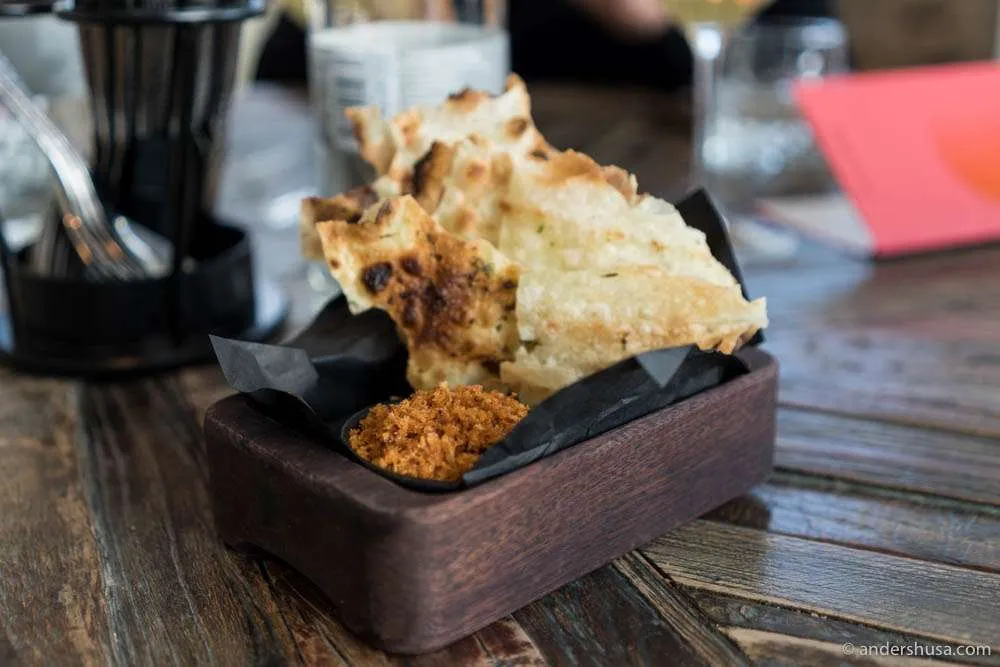 Knuspriges Fladenbrot mit scharfer Paprikapaste und Panko-Bröseln, serviert im NOA Restaurant