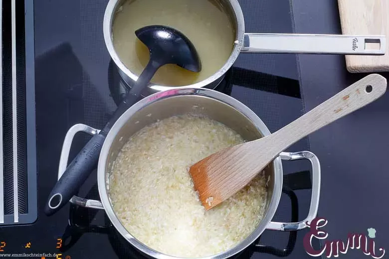 Kochlöffel rührt Risotto im Topf, um die cremige Konsistenz zu entwickeln