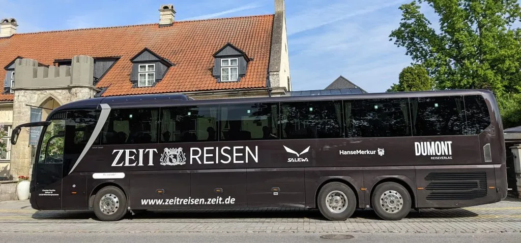 Komfortabler Reisebus vor einer grünen Landschaft
