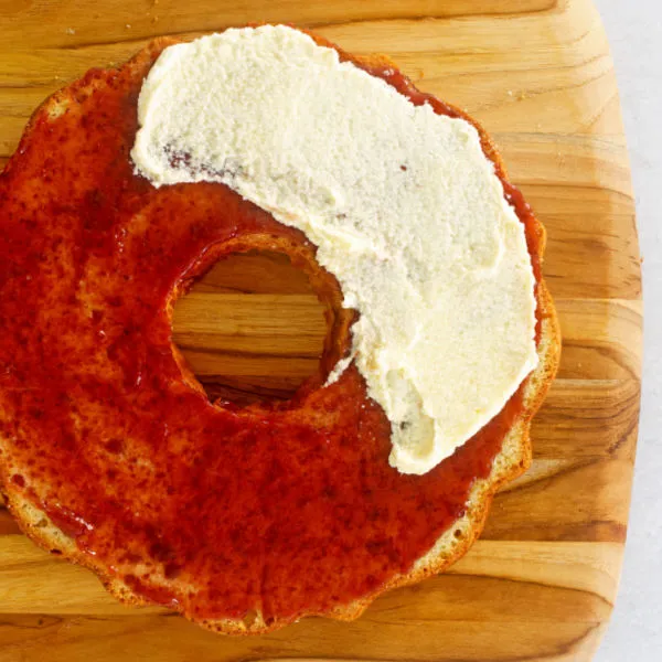 Konfitüre auf die unterste Schicht streichen und mit Buttercreme bedecken