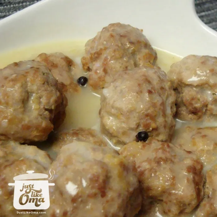 Königsberger Klopse serviert mit Salzkartoffeln und Kapern in der hellen Sahnesauce.