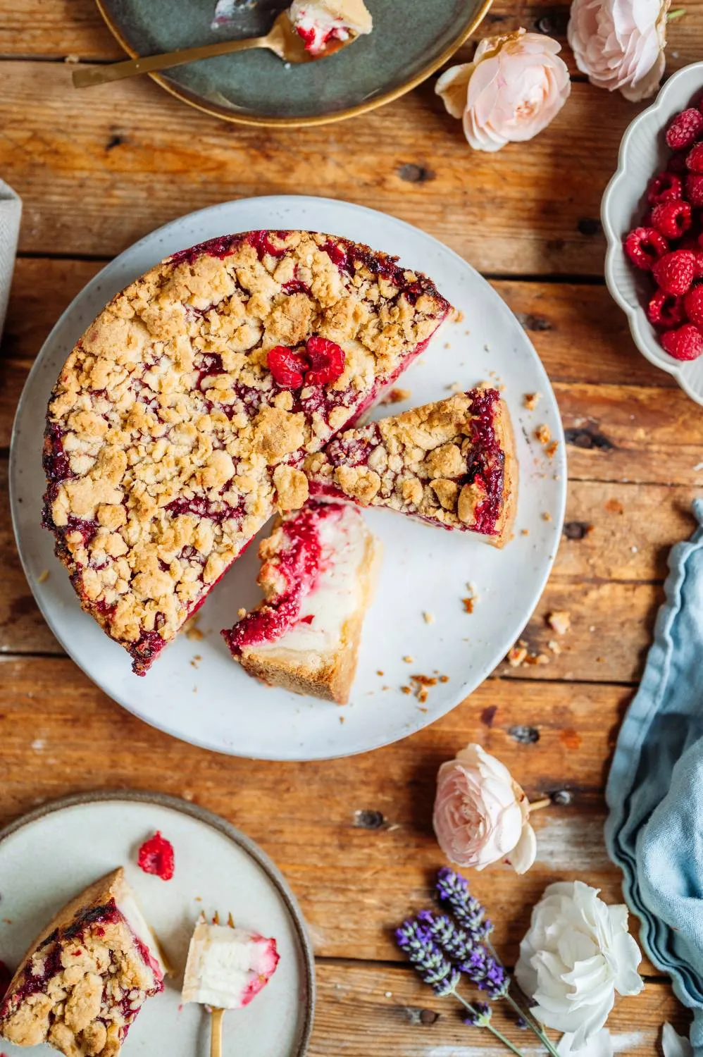 Köstliche Stücke des Joghurt-Cheesecakes mit Himbeeren und knusprigen Streuseln, ideal für den Geburtstagstisch im Sommer