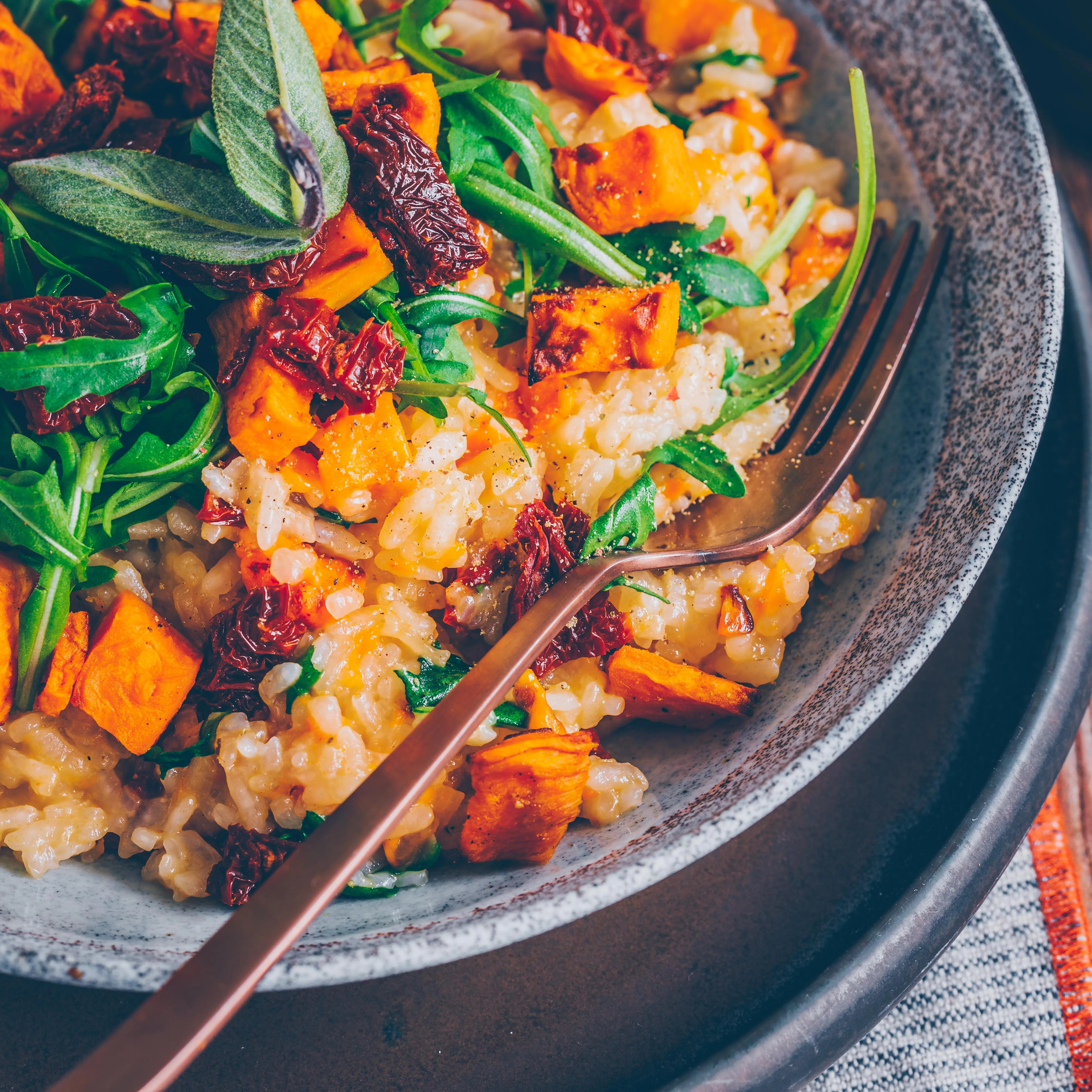 Köstliches Süßkartoffel-Risotto auf einem Holztisch, bereit zum Servieren