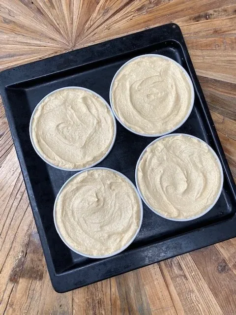 Kreative Osterdekorationen auf der Oberseite einer gesprenkelten Ostertorte, darunter diverse Schokoladenfiguren.