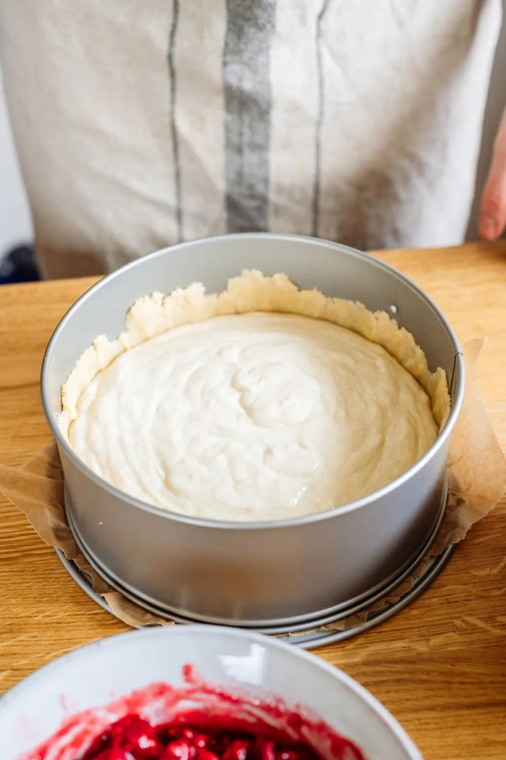 Kuchenboden aus Streuselteig in einer Springform ausgelegt, bereit für die Füllung des Geburtstagskuchens