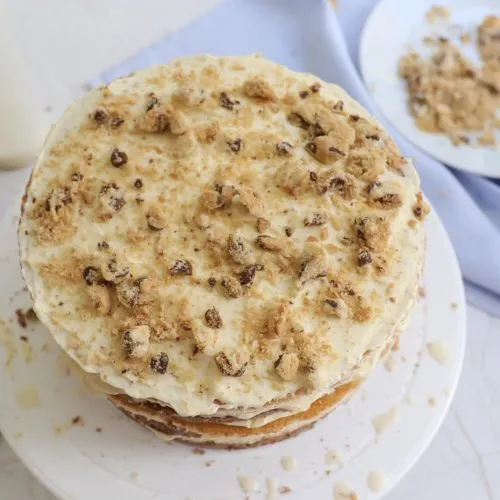 Kuchenfüllung aus Sahne und Kekskrümeln auf einem Tortenboden verteilen