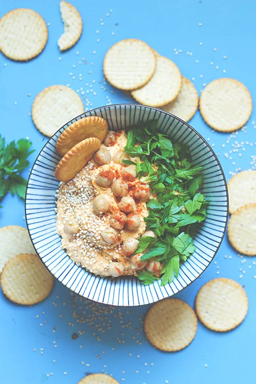 Kürbis-Hummus in einer Schale mit Brot und Gewürzen