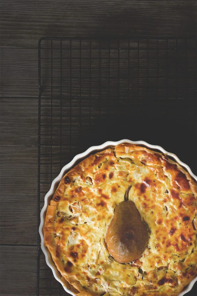 Kürbisquiche mit Lauch und Birne auf einem Holzbrett